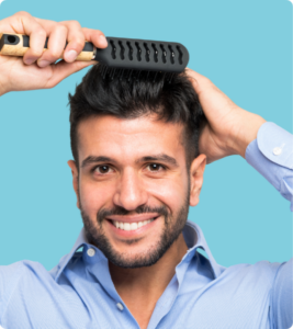Homme souriant se coiffant avec une brosse